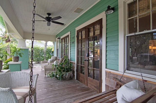 wooden terrace with a porch, french doors, and ceiling fan