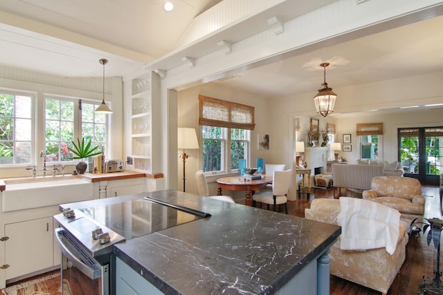 kitchen with stainless steel electric range oven, sink, pendant lighting, a notable chandelier, and white cabinetry