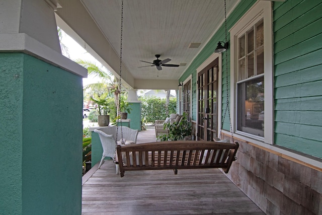 wooden terrace with ceiling fan and covered porch