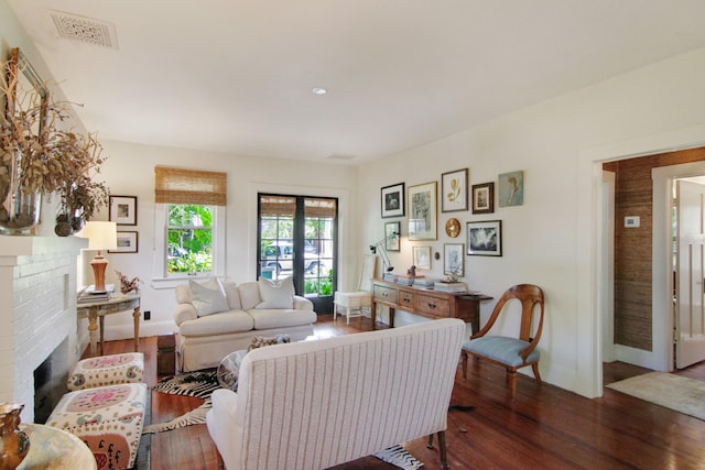 living room featuring a fireplace, french doors, and dark hardwood / wood-style flooring