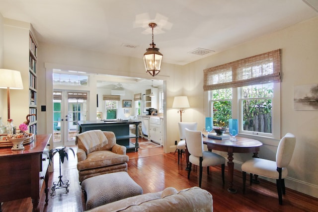 living room featuring an inviting chandelier, wood-type flooring, and french doors