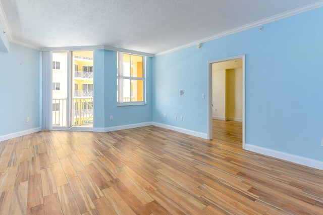 unfurnished room with expansive windows, crown molding, a textured ceiling, and light hardwood / wood-style flooring