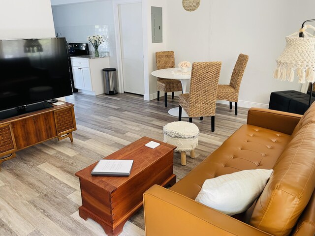 living room with light wood-type flooring and electric panel