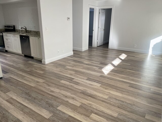 unfurnished living room featuring light hardwood / wood-style flooring and sink