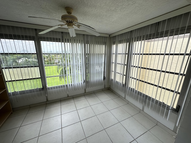 unfurnished sunroom featuring ceiling fan