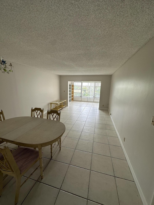 unfurnished dining area featuring light tile patterned flooring and a textured ceiling