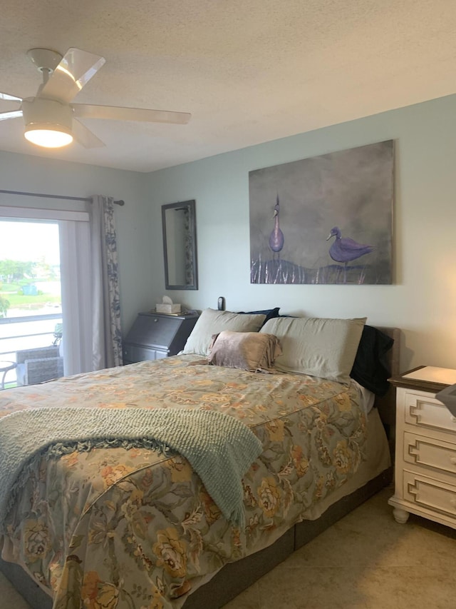 bedroom with ceiling fan and a textured ceiling