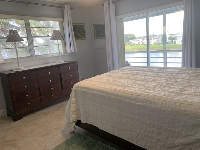 tiled bedroom with multiple windows and a water view