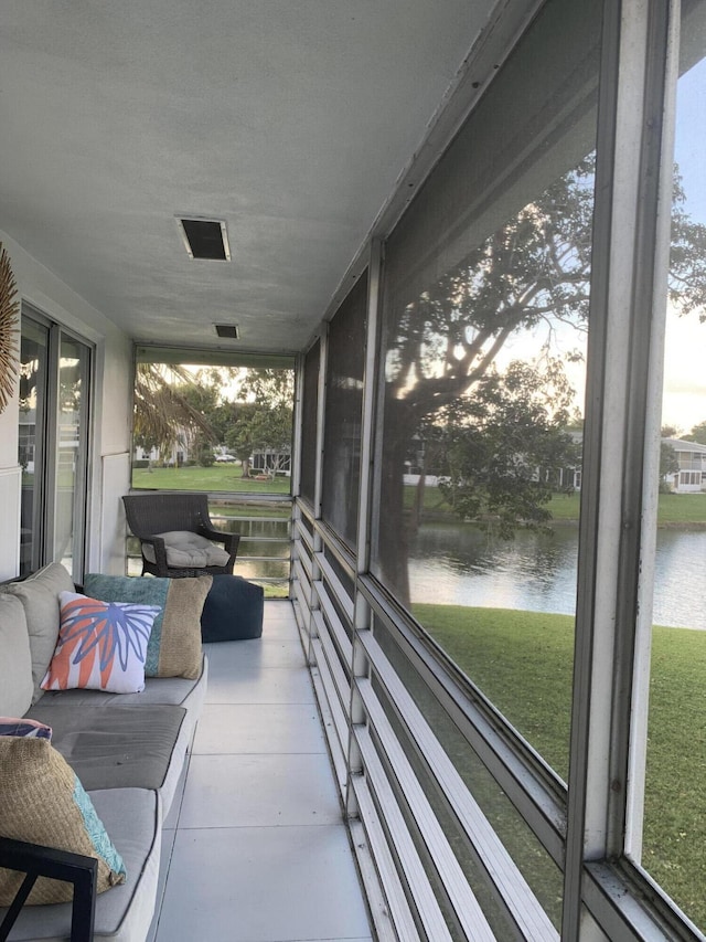 sunroom / solarium featuring a water view