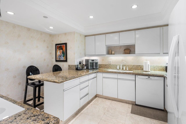 kitchen featuring sink, white cabinetry, white appliances, kitchen peninsula, and crown molding