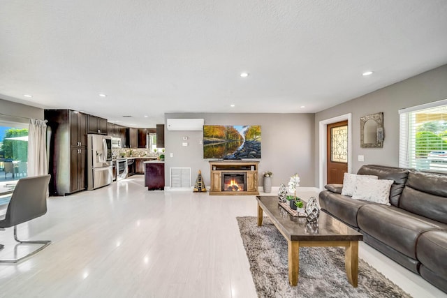 living room featuring light wood-type flooring and a textured ceiling