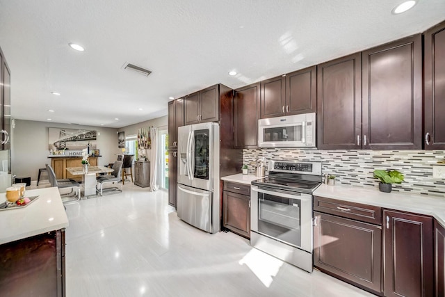 kitchen with backsplash, dark brown cabinetry, and stainless steel appliances