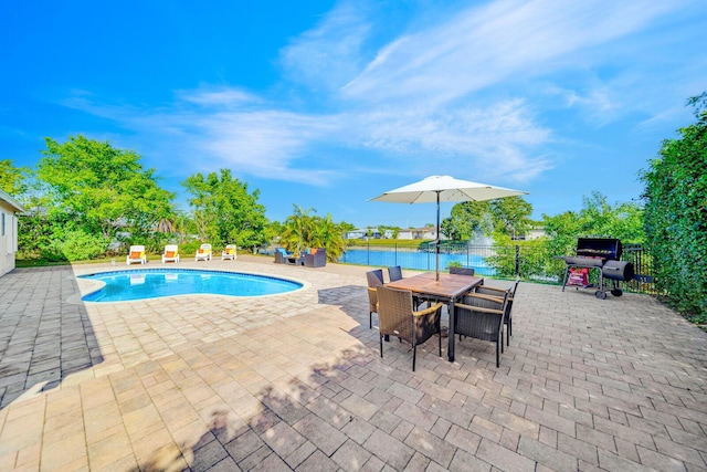 view of swimming pool with a water view, grilling area, and a patio