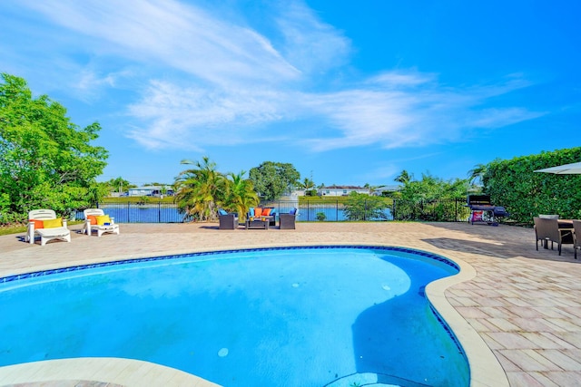 view of pool featuring a water view and a patio