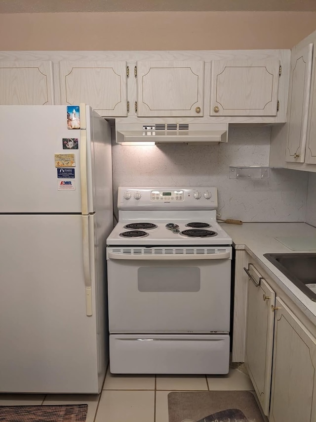 kitchen with white appliances, ventilation hood, sink, light tile patterned floors, and white cabinetry