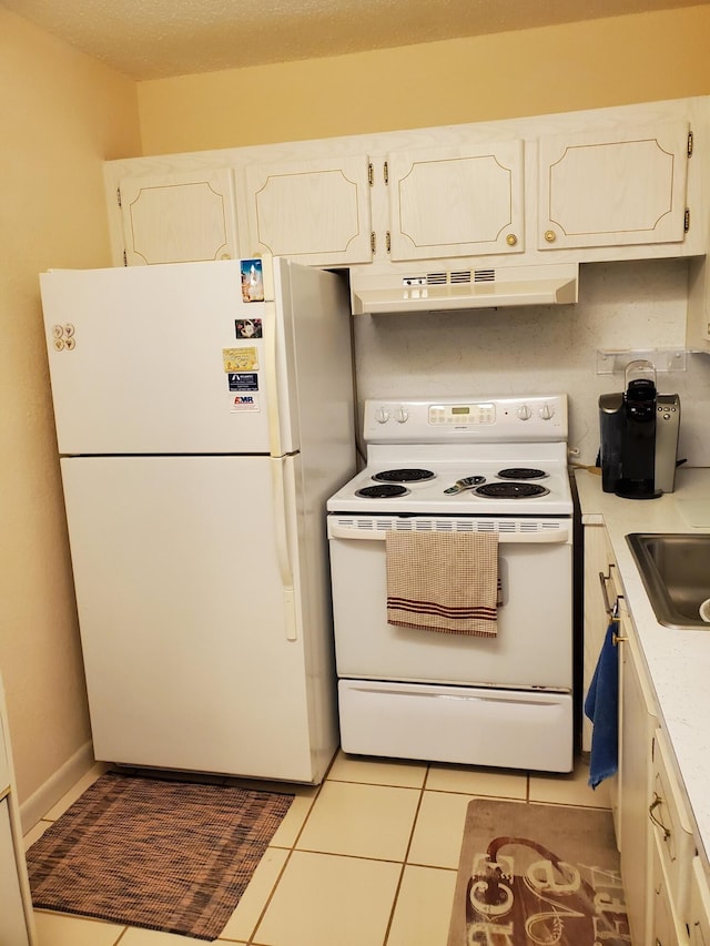 kitchen featuring light tile patterned floors, white appliances, white cabinetry, and sink