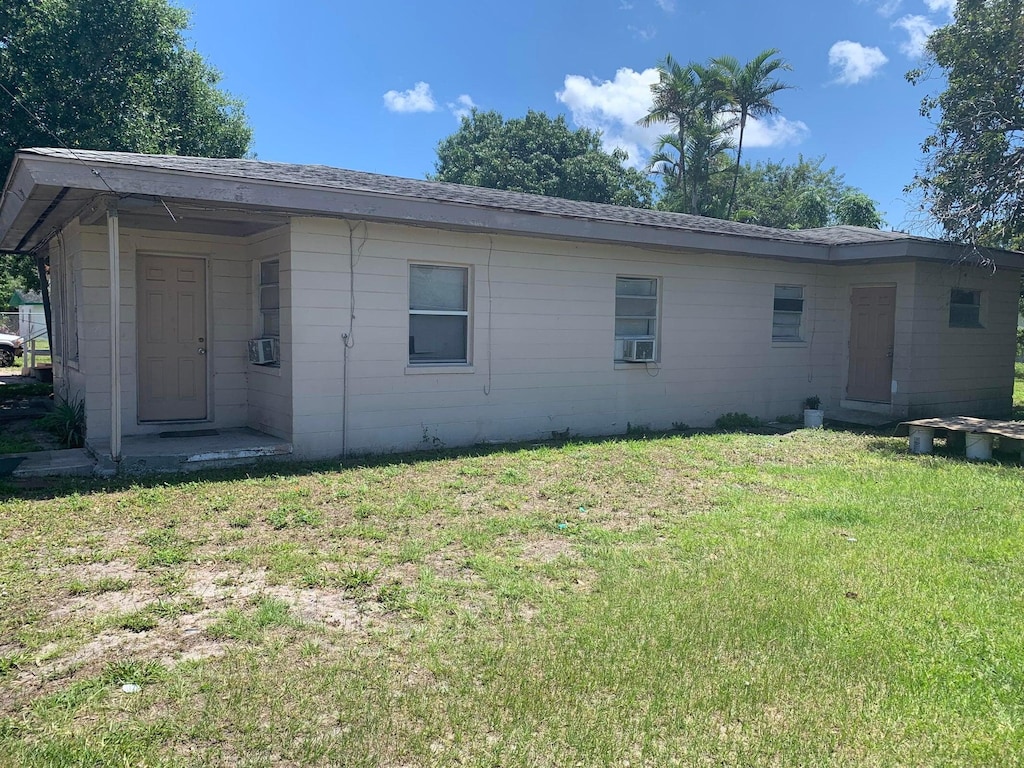 rear view of property with a lawn