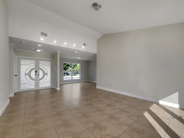 tiled spare room featuring vaulted ceiling and ornamental molding