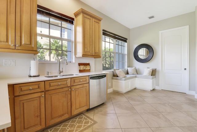 kitchen with a healthy amount of sunlight, sink, light tile patterned floors, and dishwasher