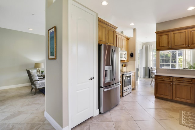 kitchen with light tile patterned flooring and appliances with stainless steel finishes