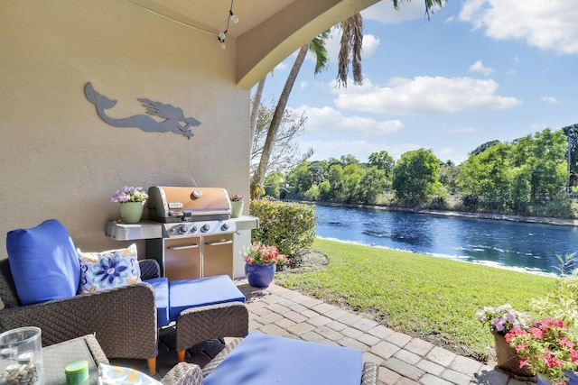 view of patio / terrace with area for grilling and a water view