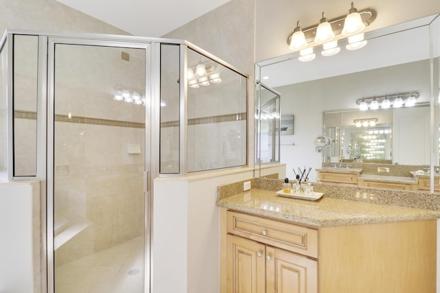 bathroom featuring vanity and a shower with shower door