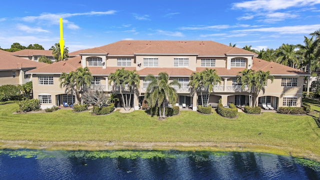 rear view of property featuring a water view and a yard