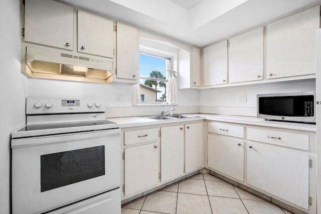 kitchen featuring light tile patterned floors, electric range, and sink