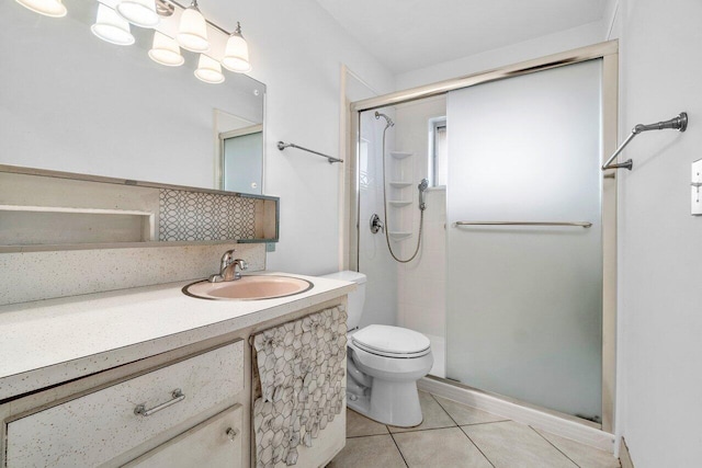 bathroom featuring a shower with shower door, vanity, tile patterned floors, and toilet