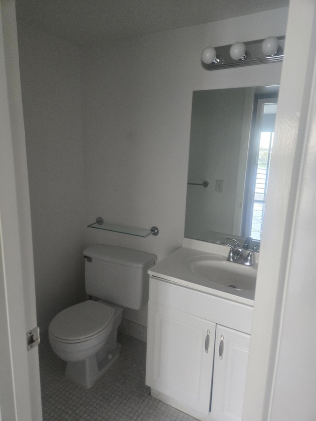 bathroom with tile patterned flooring, vanity, and toilet