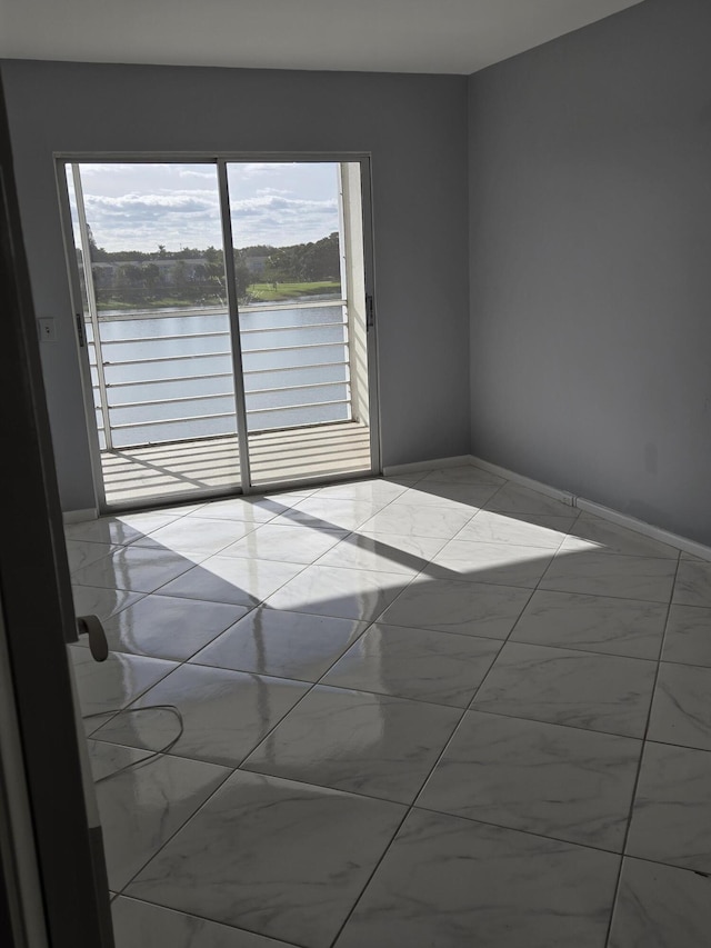 unfurnished room with a healthy amount of sunlight and a water view