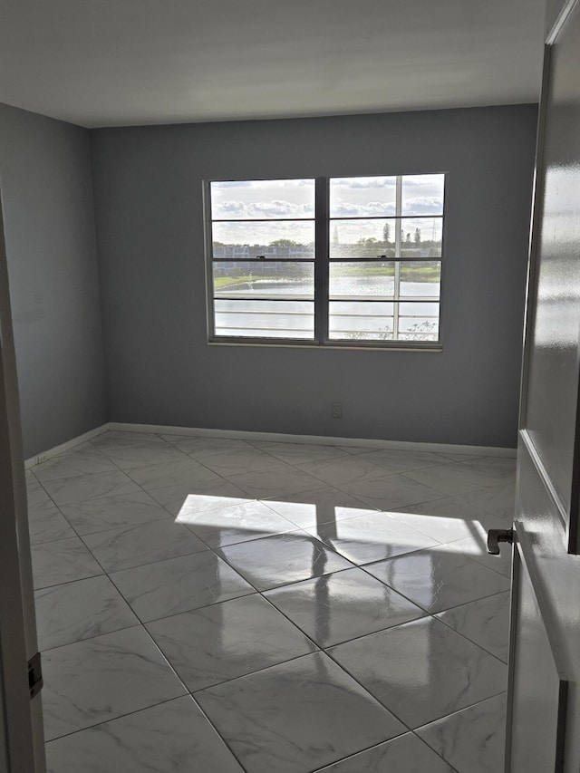 unfurnished room with a water view