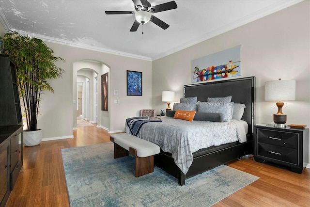 bedroom featuring hardwood / wood-style flooring, ceiling fan, crown molding, and ensuite bathroom