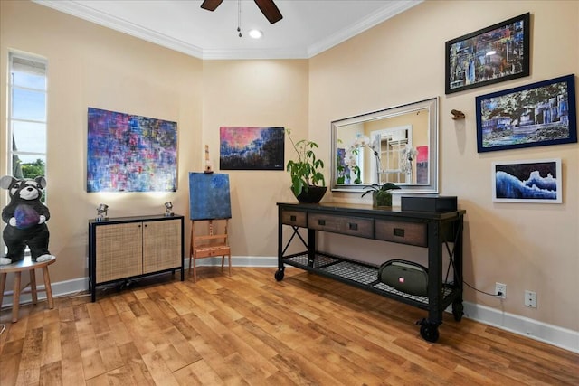 miscellaneous room featuring ceiling fan, crown molding, and light wood-type flooring