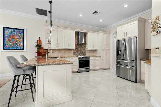 kitchen featuring sink, hanging light fixtures, stainless steel appliances, wall chimney range hood, and light stone counters