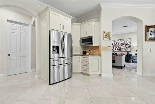 kitchen with light stone counters, ornamental molding, and stainless steel appliances