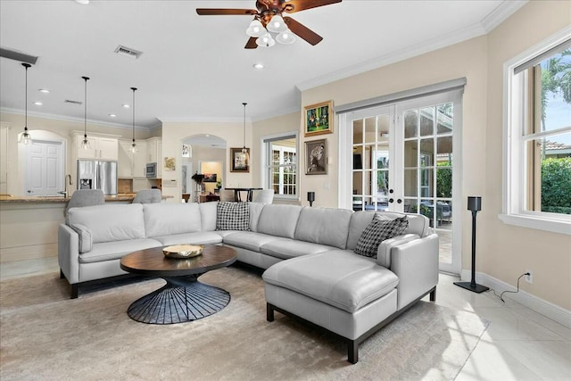 living room with french doors, ceiling fan, crown molding, and light tile patterned flooring