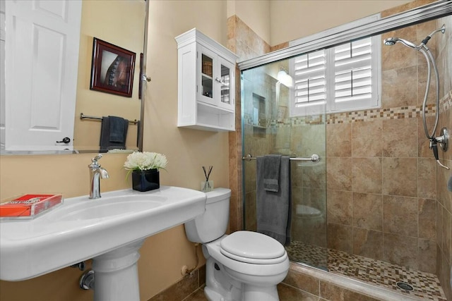 bathroom with walk in shower, sink, and toilet