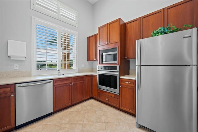 kitchen with sink, light tile patterned floors, and stainless steel appliances