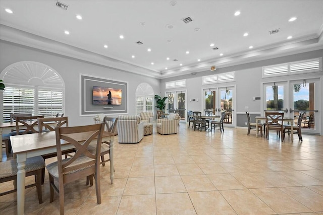 tiled dining area with crown molding and french doors