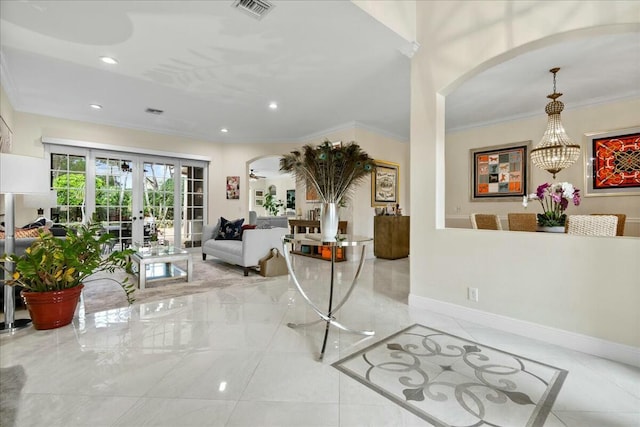 interior space with a chandelier, crown molding, and french doors