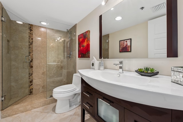 bathroom featuring tile patterned flooring, vanity, a shower with shower door, and toilet