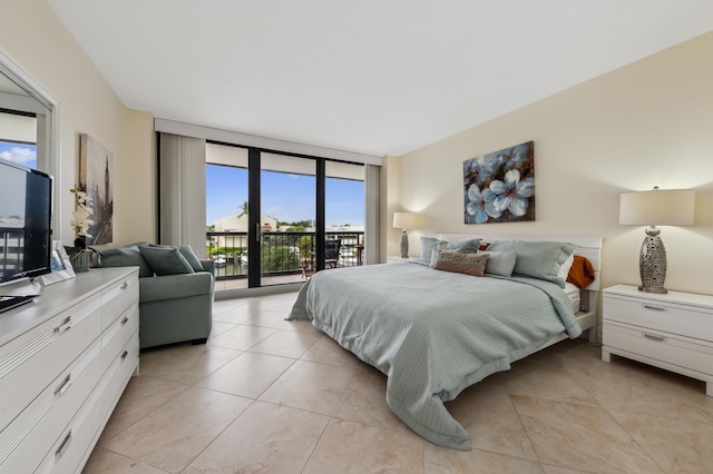 bedroom with access to outside and a wall of windows