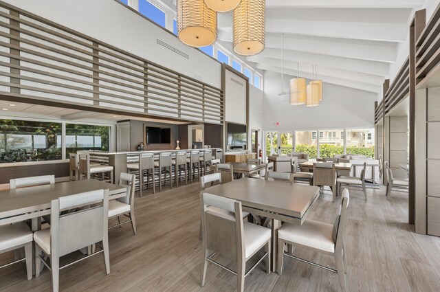 dining area with a high ceiling, a wealth of natural light, and wood-type flooring