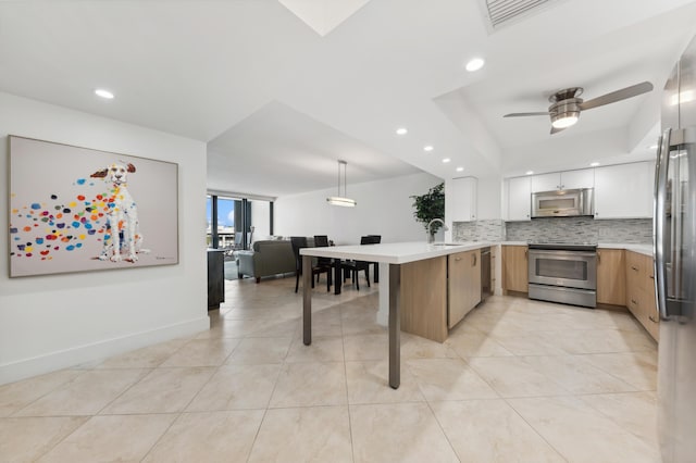 kitchen with white cabinetry, ceiling fan, kitchen peninsula, pendant lighting, and appliances with stainless steel finishes