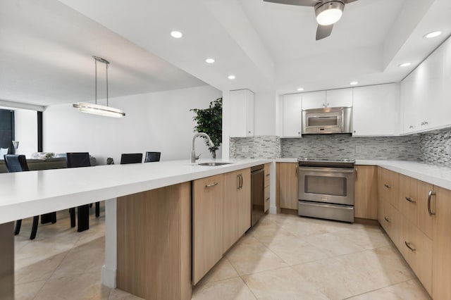 kitchen with stainless steel appliances, ceiling fan, sink, pendant lighting, and white cabinets