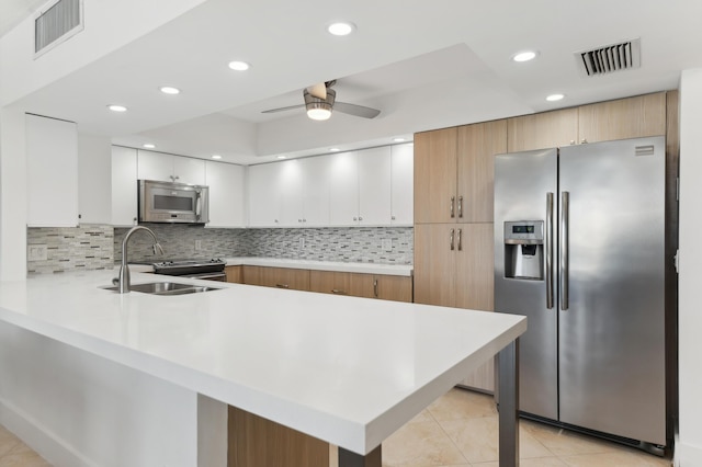4748 S Ocean Blvd Unit 306, Highland Beach, FL 33487 - kitchen featuring appliances with stainless steel finishes, a sink, a peninsula, light tile patterned floors, and light countertops