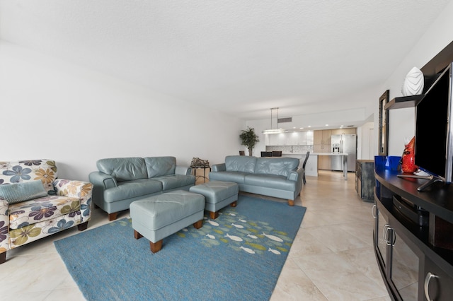 living room featuring light tile patterned floors and a textured ceiling