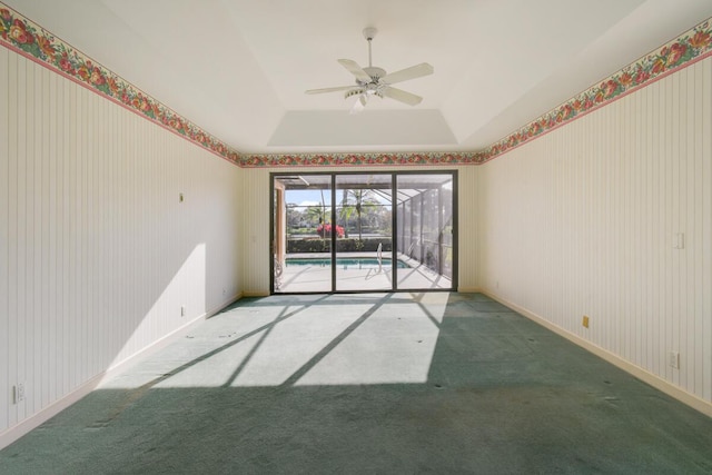 empty room featuring carpet flooring, ceiling fan, and a raised ceiling