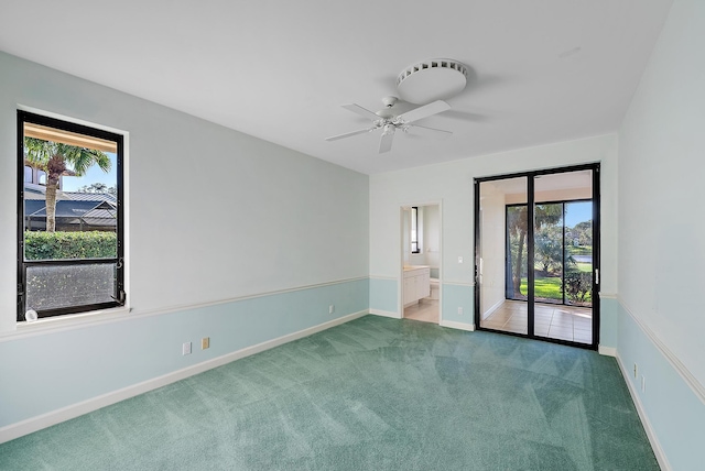 carpeted spare room featuring ceiling fan